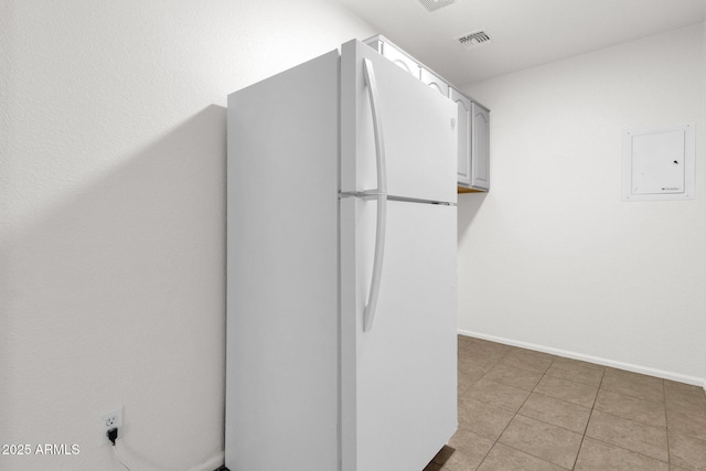 interior space with visible vents, baseboards, tile patterned floors, and electric panel