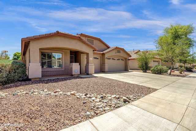 view of front of property featuring stucco siding, an attached garage, driveway, and a tile roof