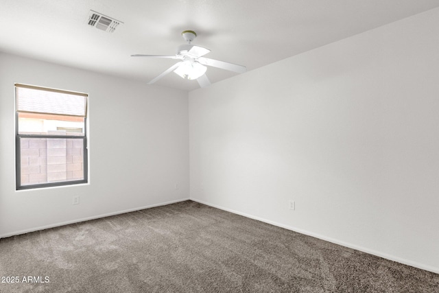 carpeted spare room with baseboards, a ceiling fan, and visible vents