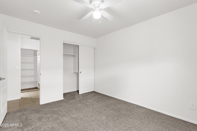 unfurnished bedroom featuring baseboards, carpet, a closet, and visible vents