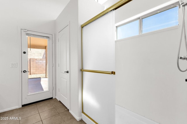 doorway to outside featuring baseboards and light tile patterned floors