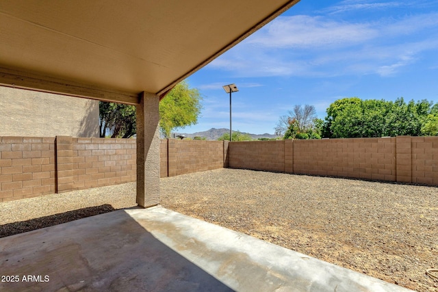 view of yard with a fenced backyard, a patio, and a mountain view