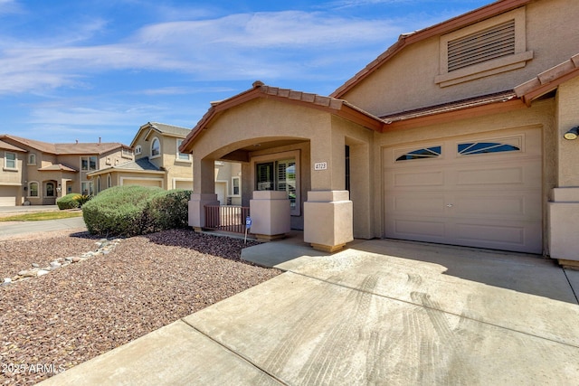 view of front of property with an attached garage, stucco siding, and driveway