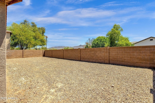 view of yard with a fenced backyard and a mountain view