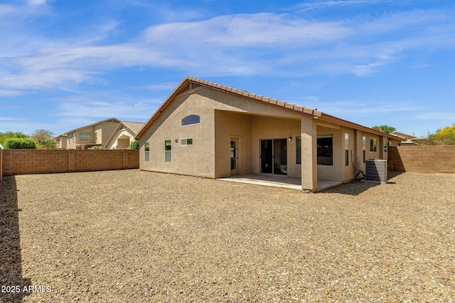 rear view of property with central AC unit, a patio area, stucco siding, and a fenced backyard