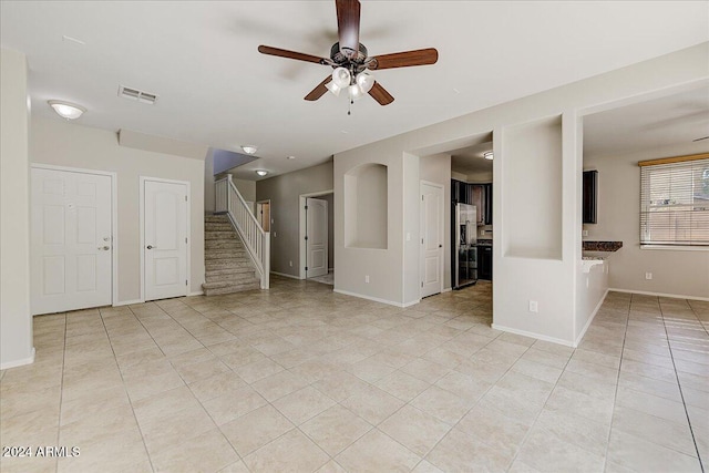 unfurnished living room with light tile patterned floors and ceiling fan