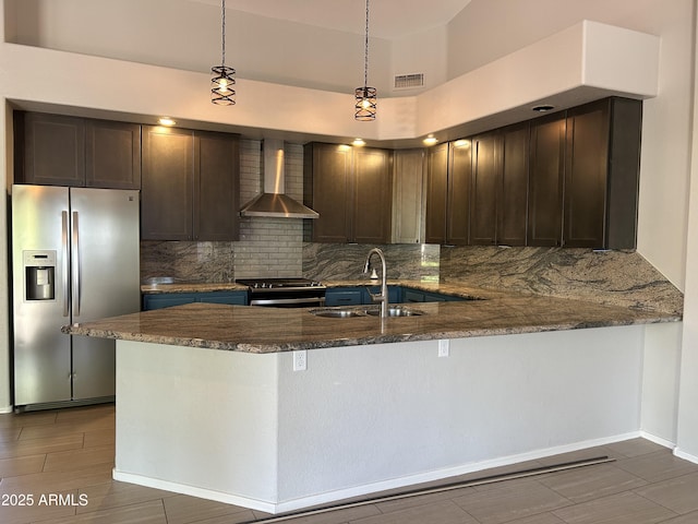 694 W Beechnut Dr, Chandler, AZ 85248 - kitchen with stainless steel appliances, wall chimney range hood, tasteful backsplash, a peninsula, and dark stone countertops