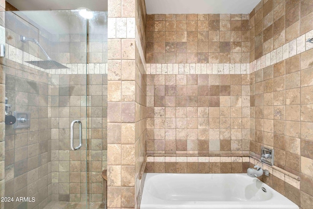 bathroom featuring separate shower and tub