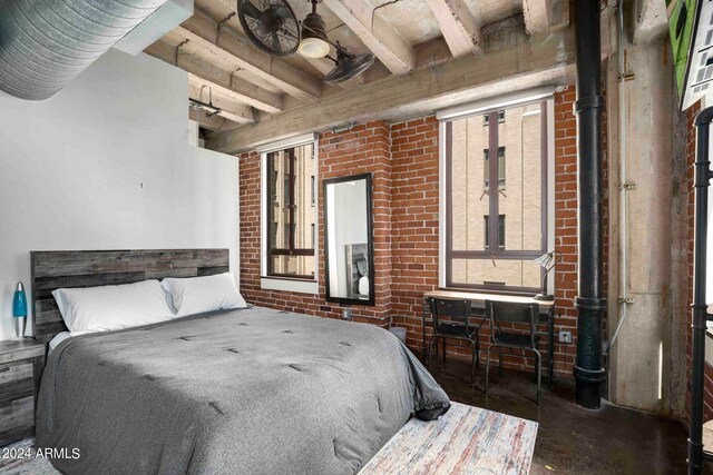 bedroom with beam ceiling and brick wall