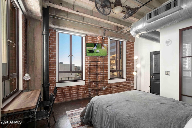 bedroom with ceiling fan and brick wall