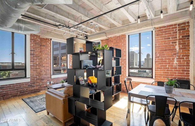 interior space with light hardwood / wood-style flooring and brick wall