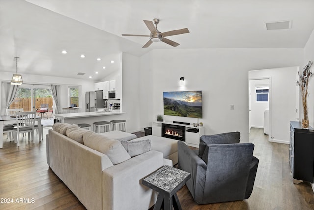 living room with lofted ceiling, sink, wood-type flooring, and ceiling fan