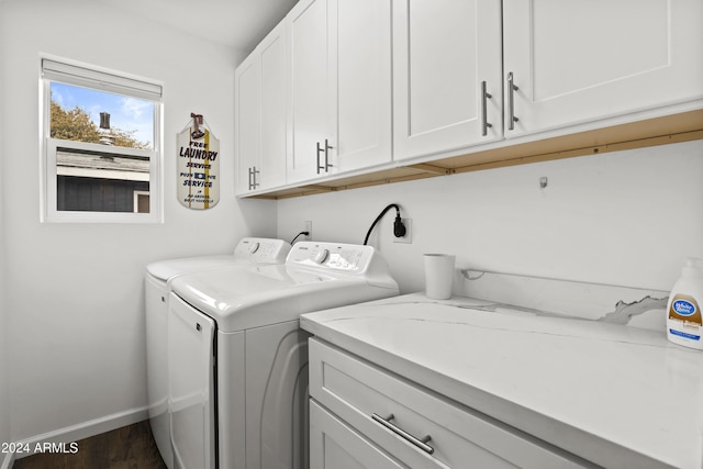 laundry room featuring cabinets, washing machine and dryer, and dark wood-type flooring