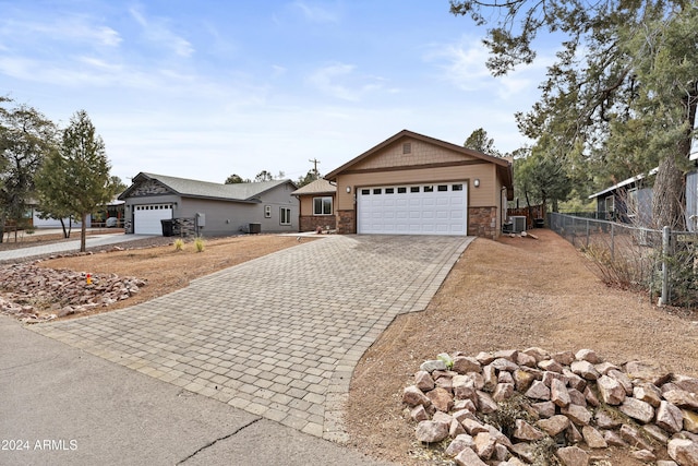 ranch-style house with a garage and central air condition unit