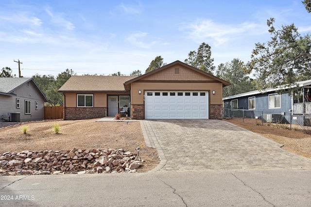 single story home featuring a garage and central air condition unit