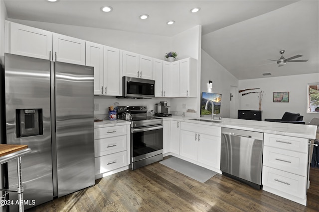 kitchen featuring white cabinetry, appliances with stainless steel finishes, lofted ceiling, and kitchen peninsula