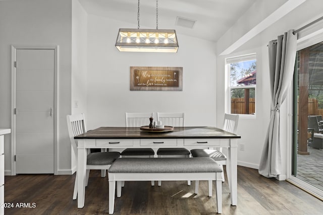 dining space featuring lofted ceiling and dark hardwood / wood-style floors