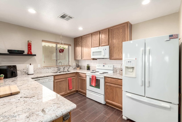 kitchen featuring white appliances, a sink, visible vents, backsplash, and wood tiled floor