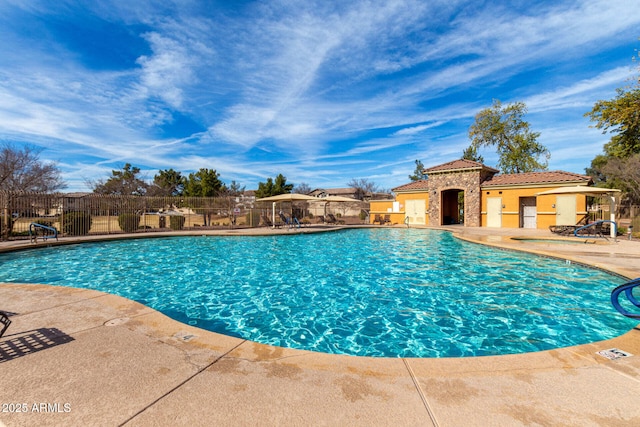 community pool with fence and a patio