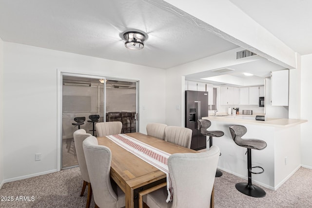 carpeted dining room featuring sink