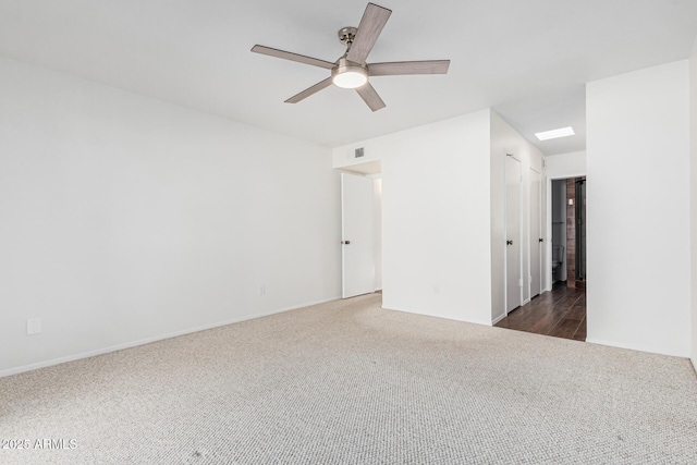 unfurnished room featuring ceiling fan and dark colored carpet