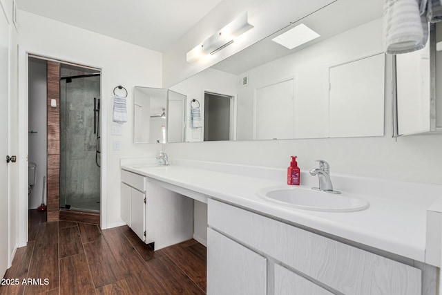 bathroom featuring vanity, hardwood / wood-style flooring, and a shower with door