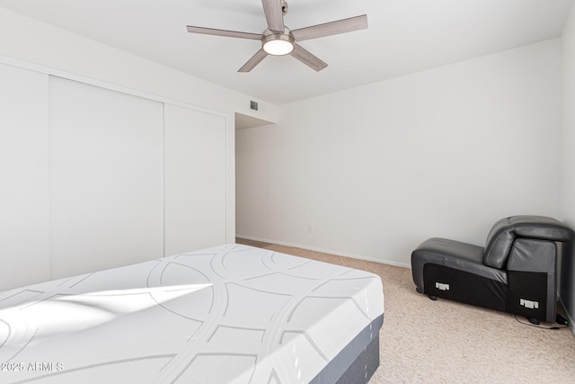 carpeted bedroom featuring ceiling fan and a closet