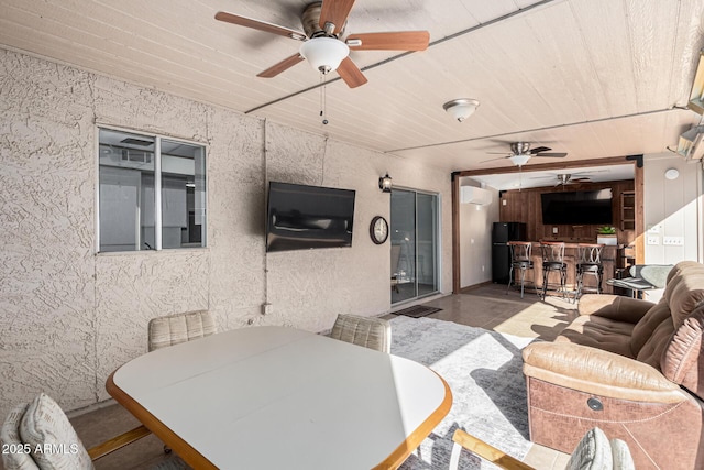 view of patio featuring a bar, ceiling fan, and a wall unit AC