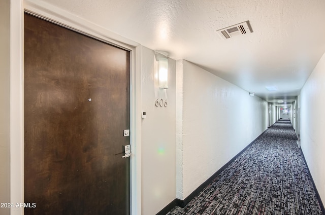 hall featuring a textured ceiling