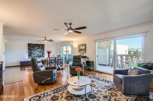 living room with hardwood / wood-style flooring, ceiling fan, and crown molding