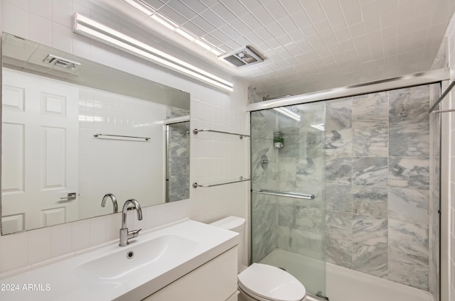 bathroom featuring vanity, toilet, and a shower with shower door