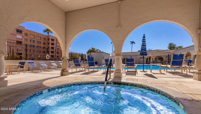 view of swimming pool with a community hot tub and a patio