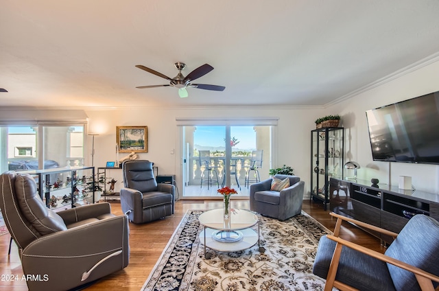 living room featuring hardwood / wood-style floors, crown molding, ceiling fan, and a healthy amount of sunlight