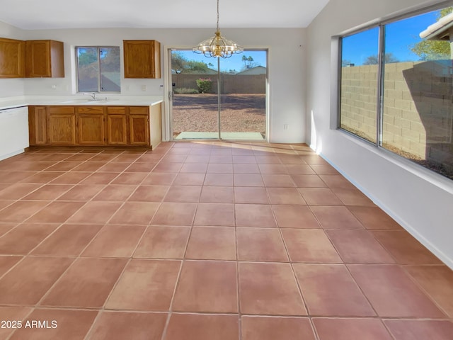 kitchen featuring light tile patterned flooring, sink, a chandelier, dishwasher, and pendant lighting