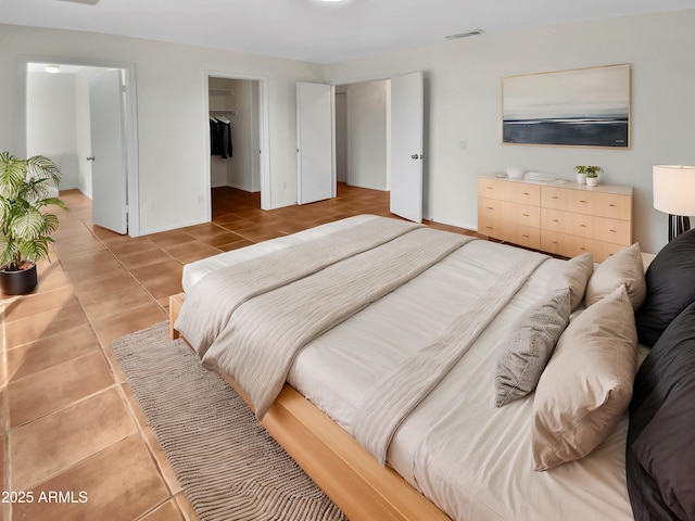 bedroom featuring a spacious closet and light tile patterned floors