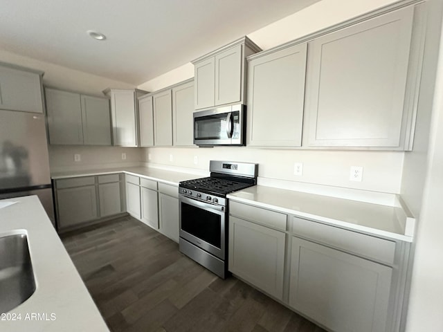 kitchen featuring dark hardwood / wood-style flooring, stainless steel appliances, gray cabinets, and sink