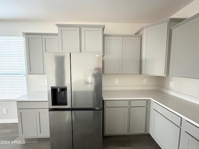 kitchen featuring gray cabinetry, dark tile patterned floors, and stainless steel refrigerator with ice dispenser