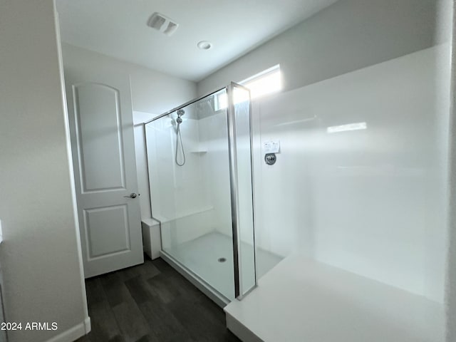 bathroom featuring wood-type flooring and a shower with shower door