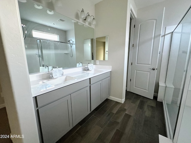 bathroom featuring hardwood / wood-style floors, vanity, and a shower with shower door