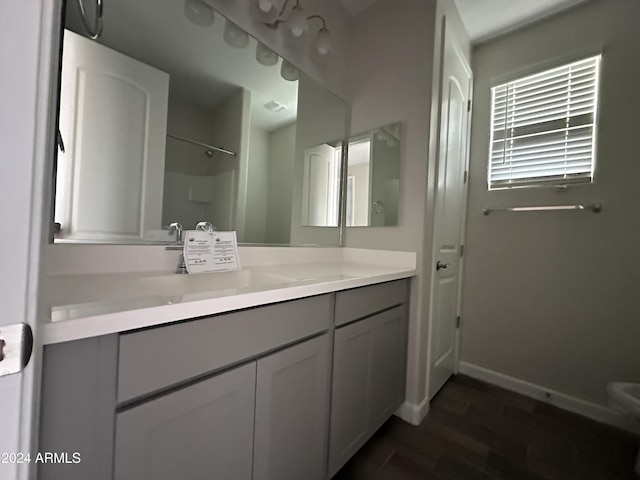 bathroom featuring a shower, vanity, and hardwood / wood-style flooring