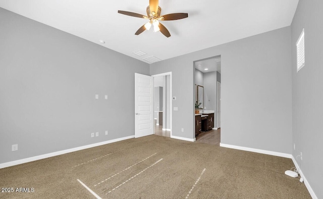 unfurnished bedroom with ceiling fan, ensuite bathroom, and carpet flooring