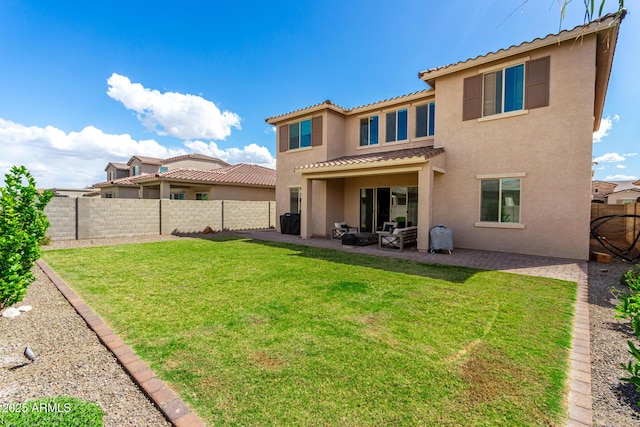 back of house featuring a yard, a fenced backyard, stucco siding, a patio area, and a tile roof