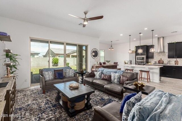 living room with ceiling fan and recessed lighting