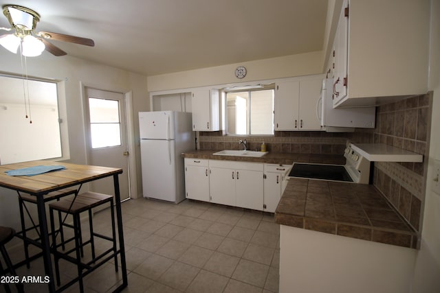 kitchen with backsplash, white appliances, sink, and white cabinets