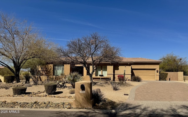 view of front of property featuring a garage, decorative driveway, and stucco siding