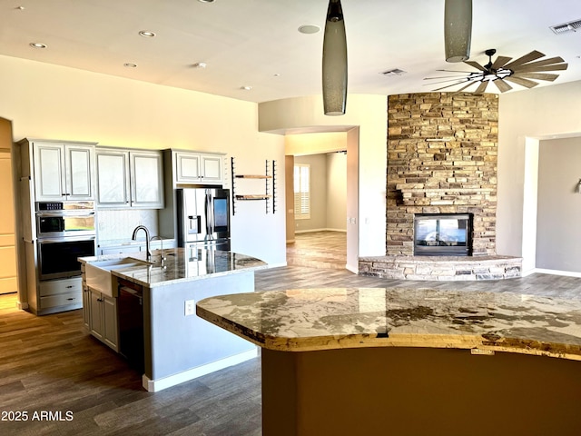 kitchen featuring stainless steel appliances, open floor plan, visible vents, and a fireplace