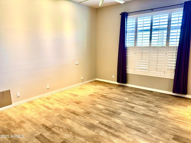 empty room featuring baseboards and wood finished floors