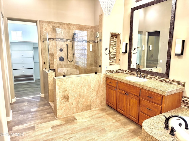 bathroom with a tile shower, wood finished floors, and vanity