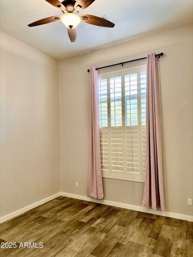 unfurnished room featuring wood finished floors, a ceiling fan, and baseboards