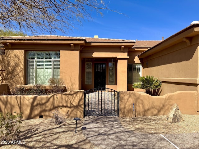 property entrance with a gate and stucco siding